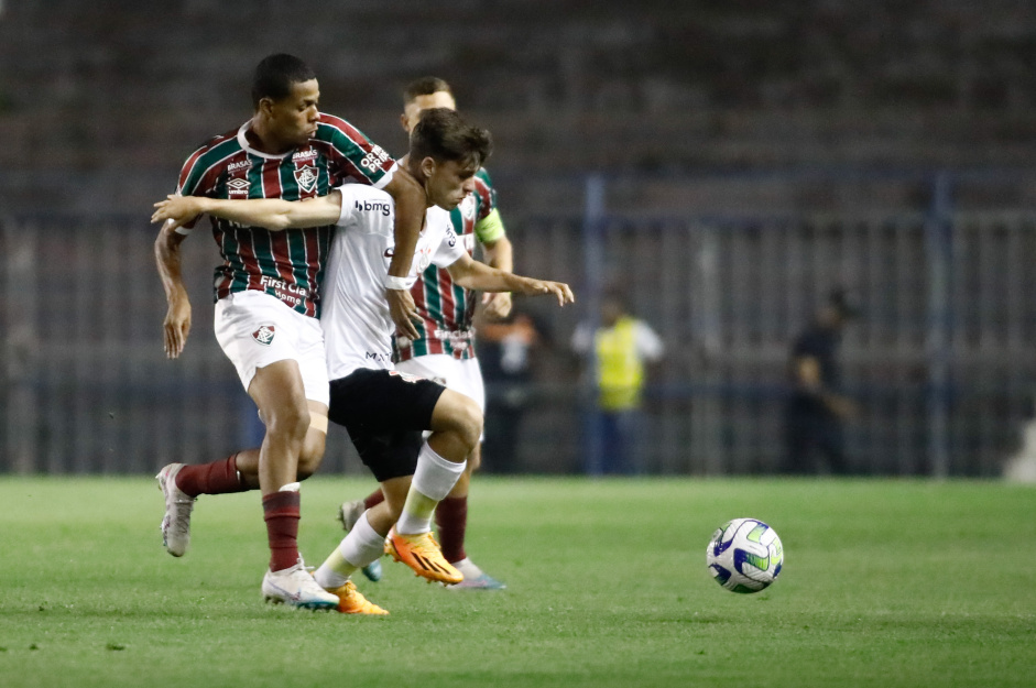 Jogador do Fluminense pressionando Breno Bidon, que protege a bola com o corpo
